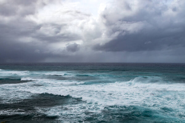 Dark storm clouds above rough waves in ominous seascape in the open ocean