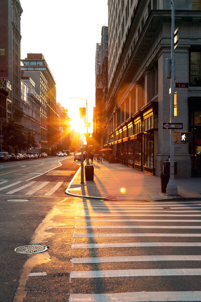 Sunset light shines on an empty crosswalk at the intersection of 23rd Street and 5th Avenue in Manhattan, New York City NYC