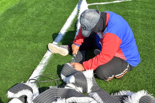 技术人员在足球场安装人工草坪 — 图库照片