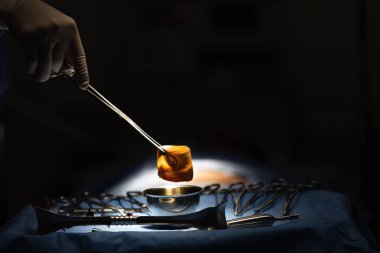 Doktor ıslatılmış ve gazlı bez yakalamak için tıbbi alet kullanın