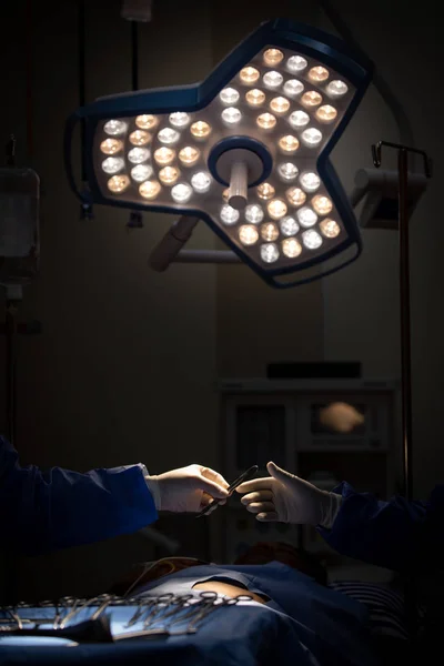 Doctors in sugery room sending medical device to other in operat — Stock Photo, Image