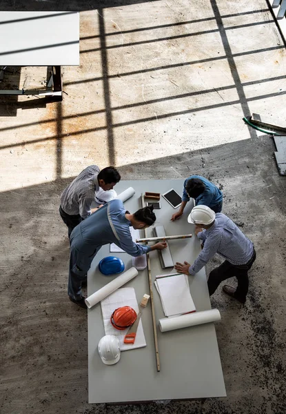 Cuatro personas equipo de ingenieros hablan juntos para revisar constucti —  Fotos de Stock