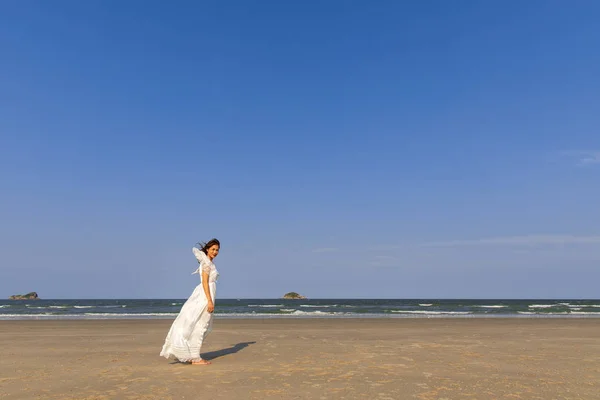 Donna in abito bianco sulla spiaggia — Foto Stock