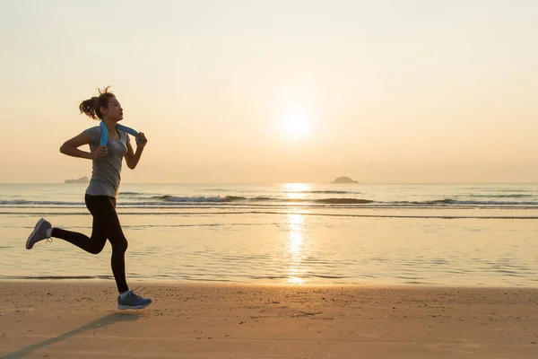 Woman running on beach at sunrise — Stock Photo, Image