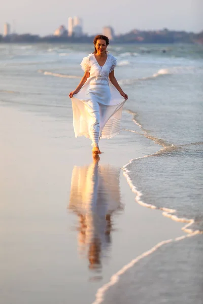 Donna in abito bianco sulla spiaggia — Foto Stock