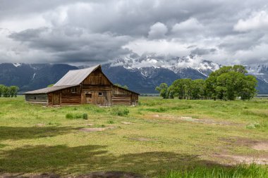 Alçak bulutlar ile eski mormon ahır Grand Teton Dağları'nda. Grand Teton Milli Parkı, Wyoming, ABD.