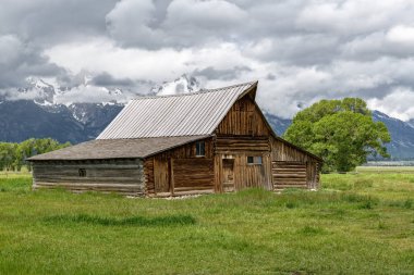Alçak bulutlar ile eski mormon ahır Grand Teton Dağları'nda. Grand Teton Milli Parkı, Wyoming, ABD.