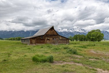 Alçak bulutlar ile eski mormon ahır Grand Teton Dağları'nda. Grand Teton Milli Parkı, Wyoming, ABD.