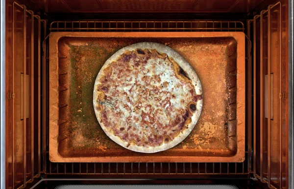 A cross section top view from above a hot operational household oven with a pizza cooking on a baking tray - 3D render