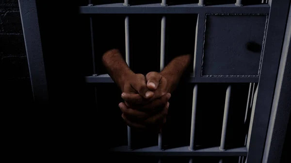 Célula de prisão e mãos negras — Fotografia de Stock