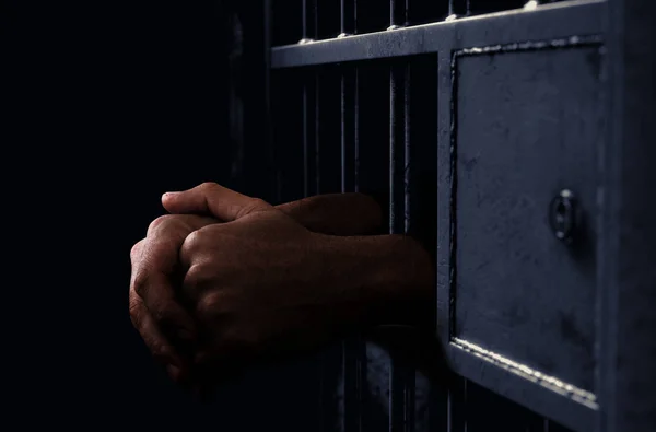 Gevangenis cel en zwarte handen — Stockfoto