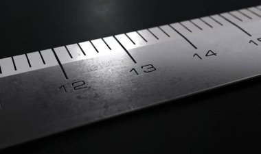 Endüstriyel çelik cetvelin 13 numaralı bölümünün aşırı yakın bir görüntüsü. Koyu, karamsar bir zemin üzerine oymalı ölçümler yapılmış.