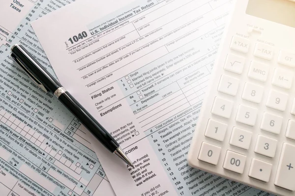 a pen to fill out an annual tax bill with a calculator to calculate the tax rate. as background business concept and finance concept with copy space  for your text or design.