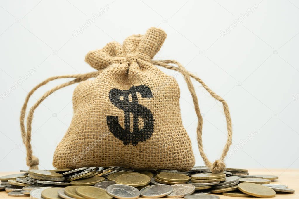 Money bags put on the pile of money. as background business concept and Saving concept with  copy space for your text or design.