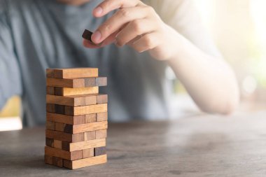 Risk söz konusu. Mühendisin eli ahşap masa tonunda tahta oyunu oynuyor. mimari proje .arkaplan iş konsepti olarak kopya alanı ile.