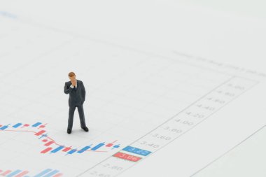 Borsa grafiğinde yer alan minyatür işadamları yatırım analizi yatırımıdır. kopyalama alanı ve beyaz alan ile arka plan iş kavramı olarak kullanılıyor.