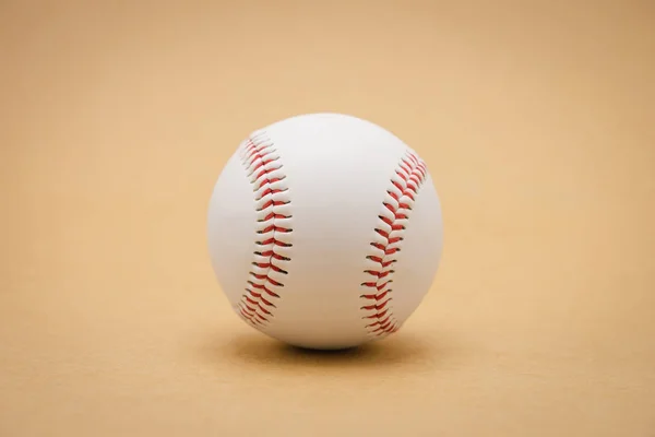 Isolated baseball on a brown background and red stitching baseba