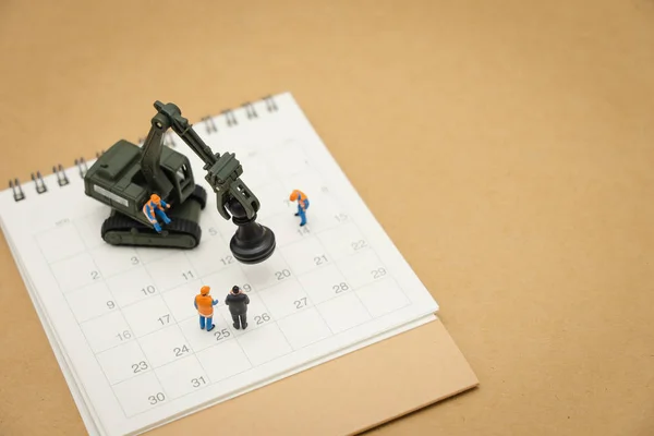 Miniatuur mensen bouwvakker reparatie met witte agenda — Stockfoto