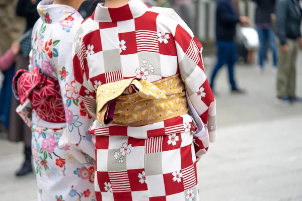 Ung flicka klädd i japansk kimono stående framför Sensoji — Stockfoto