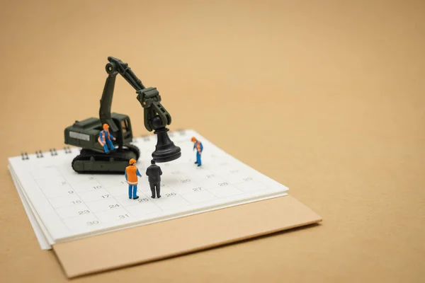 Miniature people Construction worker repair with white calendar — Stock Photo, Image
