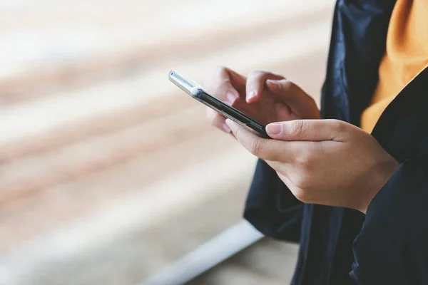 Eine schöne asiatische Frau benutzt ein Smartphone in der Innenstadt, um — Stockfoto