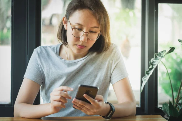 Asian girl Play smartphone For entertainment and work outside th