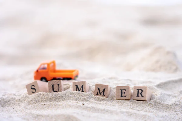 Palavra de verão escrito em bloco de madeira colocar na praia de areia. Mar v — Fotografia de Stock