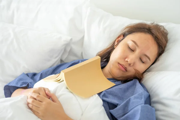 Asian girl Read books while sleeping. Man book cover Drowsiness