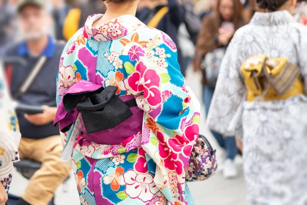 Ung flicka klädd i japansk kimono stående framför Sensoji — Stockfoto