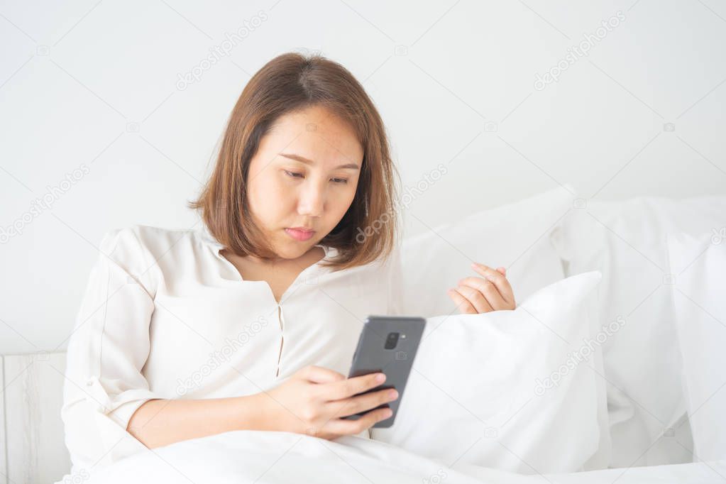 Beautiful Asian girl sleeping on a smartphone. Play on the media