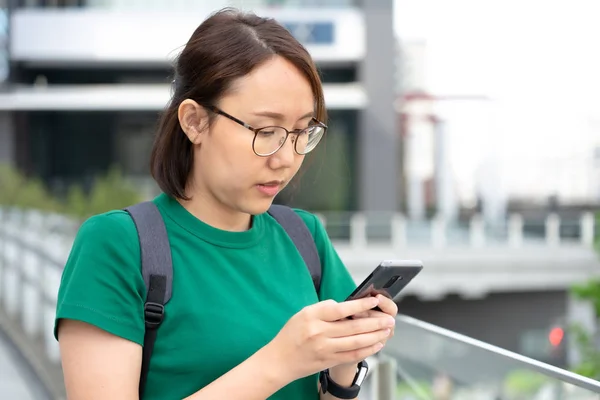 Asiatische Mädchen spielen Smartphone zur Unterhaltung und arbeiten draußen — Stockfoto