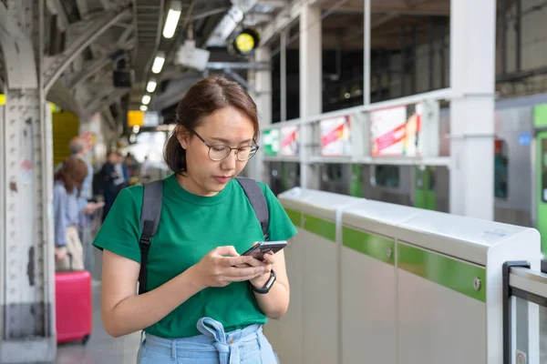 Chica asiática Jugar smartphone Para el entretenimiento y el trabajo fuera de th —  Fotos de Stock