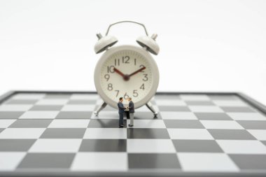 Minyatür 2 kişilik işadamı satranç bonunüzerinde duran el sıkışıyor