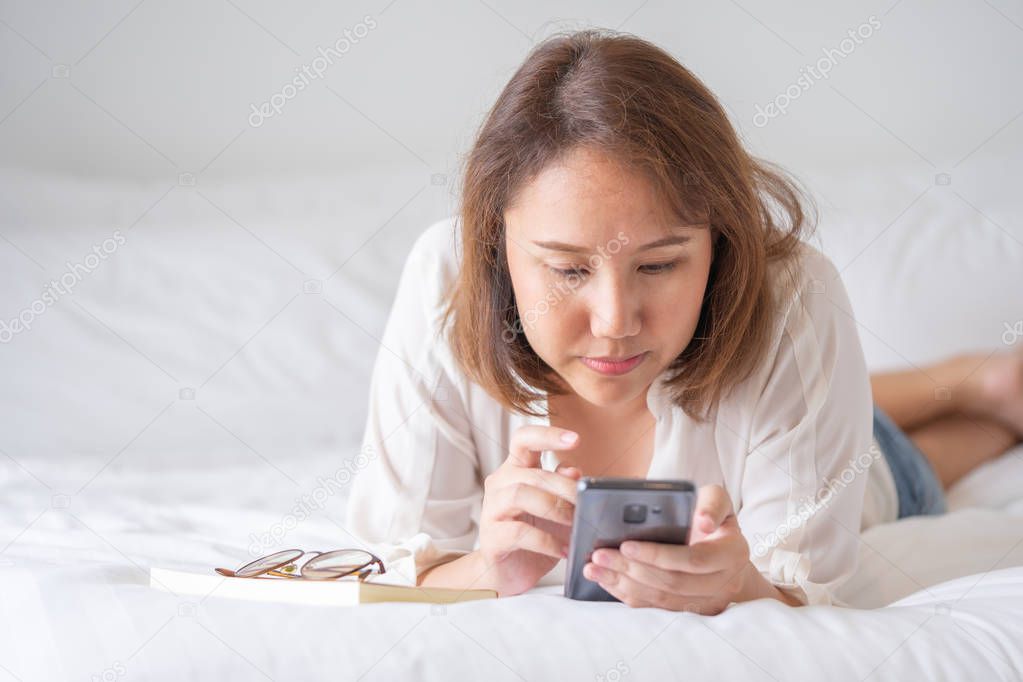 Beautiful Asian girl sleeping on a smartphone. Play on the media