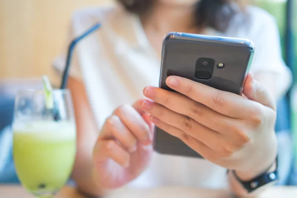 Asiatische Mädchen spielen Smartphone zur Unterhaltung und arbeiten draußen — Stockfoto