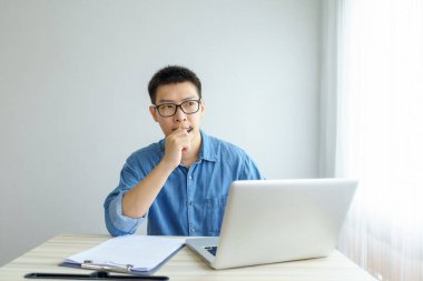 Evde çalışan genç Freelancer ya da iş adamı akıllı telefon tabletiyle çalışıyor. Çevrimiçi çalışmak ya da çalışırken öğrenmek. Ev kavramından Serbest Çalışma, İş ve Çalışma