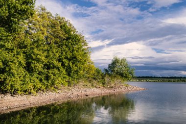 Güzel nehir manzarası. Renkli gökyüzü yansıması ile sakin nehir. Nehir akışı Sunset'teki