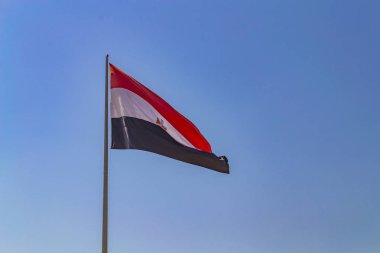 Mısır bayrağı sallayarak üzerinde mavi gökyüzü.