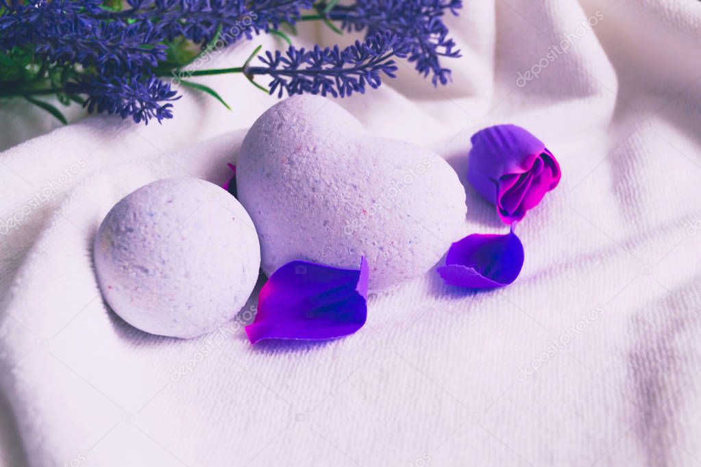 Bath bombs on white bath towel with lavender flowes.