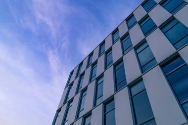 Modern ofis binasının pencerelerinde yansıyan bulutlar ile Gökyüzü. 