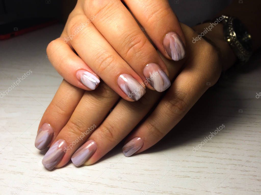 Nails care. Woman hands with  manicure on dark background. Close