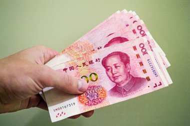 100 Çin Renminbi banknotu elinde