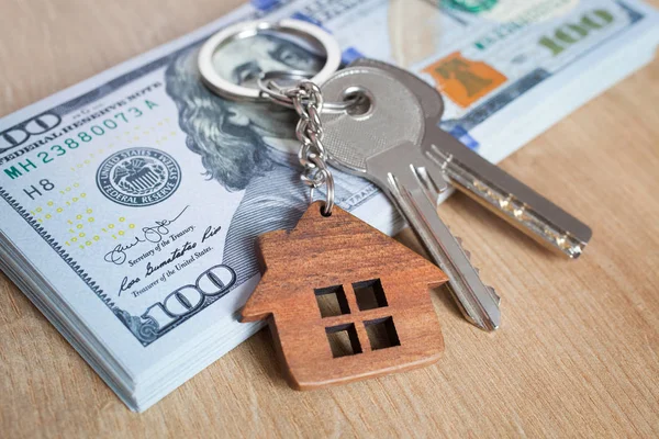 Концепция инвестирования в недвижимость. Американский доллар, наличные или жилье. Ключи крупным планом — стоковое фото