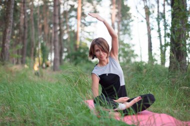 Kadın parkta açık havada tek başına yoga