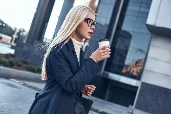 Beautiful young woman in suit holding a cup of coffee