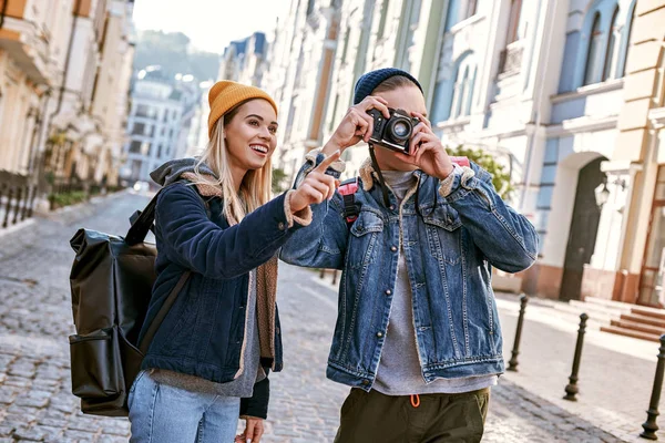 Young couple of travel bloggers are trying to take a photo in unfamiliar city