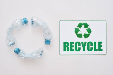 You can clean the world. Isolated recycle symbol and crumple plastic bottles