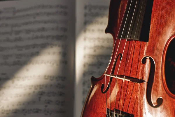 Preparing for a concert. Classic brown violin on music score sheet background. Musical instruments.