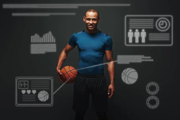 He is a new champion. Handsome sportsman standing over dark background with basketball ball in his hand. Game concept with graphic drawing.