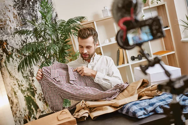 Fashion clothes. Portrait of bearded male blogger recording new video content about stylish clothes for his vlog.